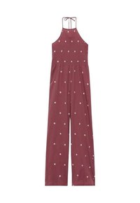 Maroon halter jumpsuit with a smocked bodice, wide-leg pants, and scattered white polka dot pattern. Adjustable tie at the back neckline.