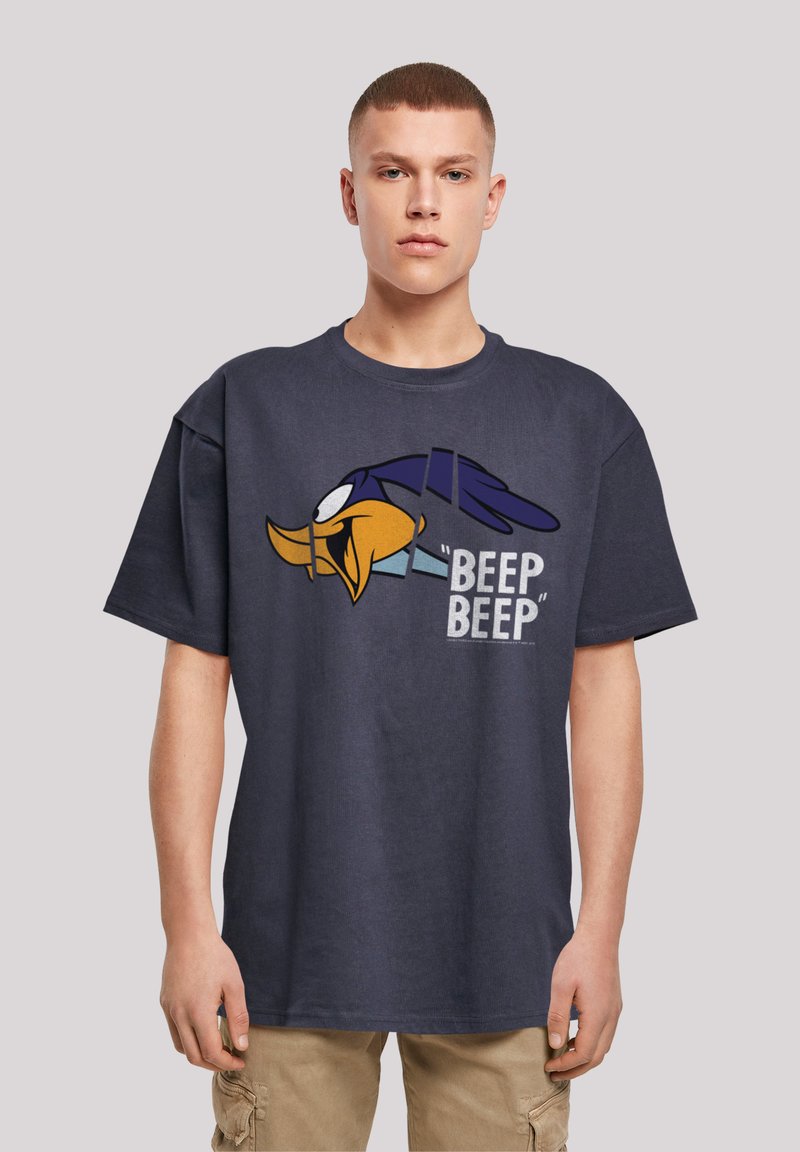 Marineblå oversized t-skjorte laget av bomull, med et grafisk trykk av en tegneseriefigur i gul og blå med teksten "BEEP BEEP" i grå.