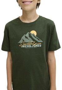 T-shirt en coton vert olive avec un graphique de montagne et de soleil dans des teintes claires et foncées, accompagné du texte "Essentials" et "Jack & Jones" en dessous.