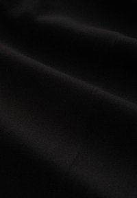 Țesătură neagră cu o textură netedă, prezentând o strălucire subtilă și plisuri pliate. Materialul pare durabil și țesut strâns.