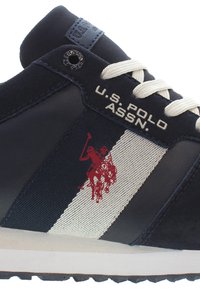 Granatowe sneakersy z białym paskiem, z czerwonym logo gracza polo, teksturowana tkanina i kremowe sznurówki. Marking U.S. Polo Assn. z boku.