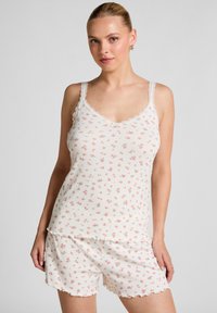 Witte tanktop met bloemenpatroon en geschulpte kanten schouderbanden, samen met bijpassende shorts. Gemaakt van lichtgewicht, textuurstof met kleine roze rozen.