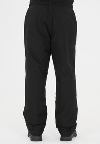 Pantalons noirs imperméables avec une taille élastique, coupe ajustée et sangles Velcro réglables aux chevilles. Texture lisse, design minimal.