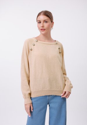 Light beige knitted sweater with a ribbed hem and cuffs. Features decorative round metallic buttons along the shoulder seam.