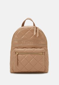Quilted tan leather backpack with a front zip pocket and gold-tone hardware. Features adjustable straps and a top handle for carrying.