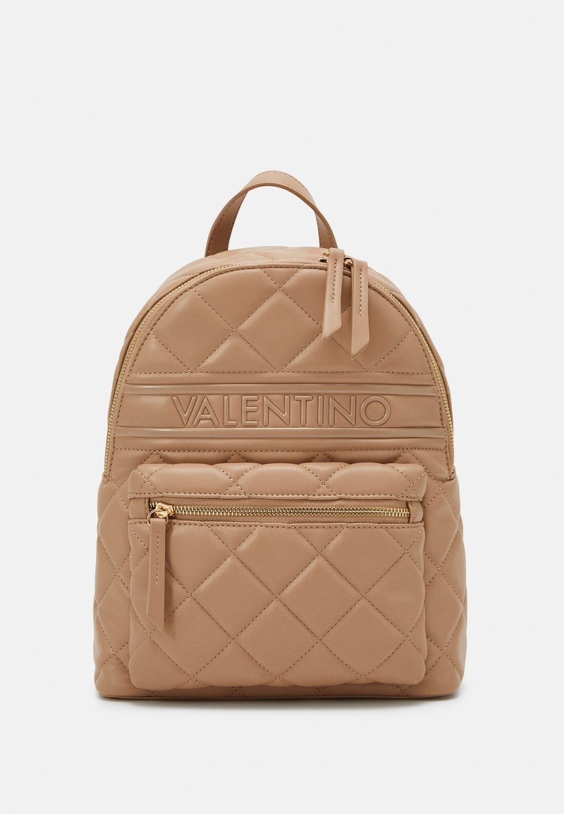 Quilted tan leather backpack with a front zip pocket and gold-tone hardware. Features adjustable straps and a top handle for carrying.