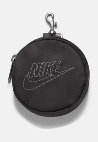 Črna okrogla torbica iz blaga z zadrgo in kovinsko sponko. Ima vezeno "Nike" logotip v sivem šivilu.