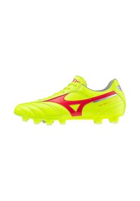Botas de fútbol en un brillante color amarillo con acentos rojos, con una parte superior de cuero suave, cordones y suela con tacos para mayor tracción.
