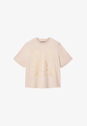 Beżowy t-shirt z krótkim rękawem z błyszczącymi złotymi literami ułożonymi pionowo na przodzie, okrągły dekolt i luźny krój.