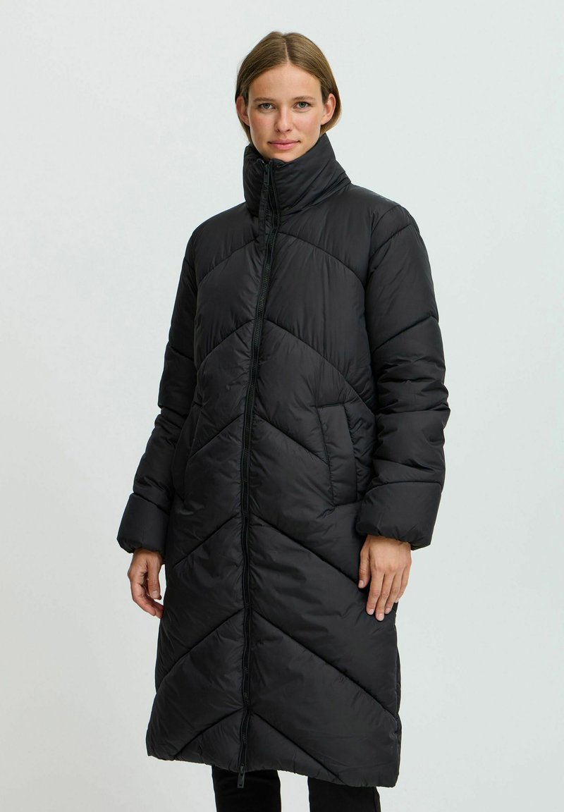 Abrigo tipo puffer negro con cuello alto, que presenta un patrón acolchado, cierre de cremallera y bolsillos laterales. Mangas largas y diseño hasta la rodilla.