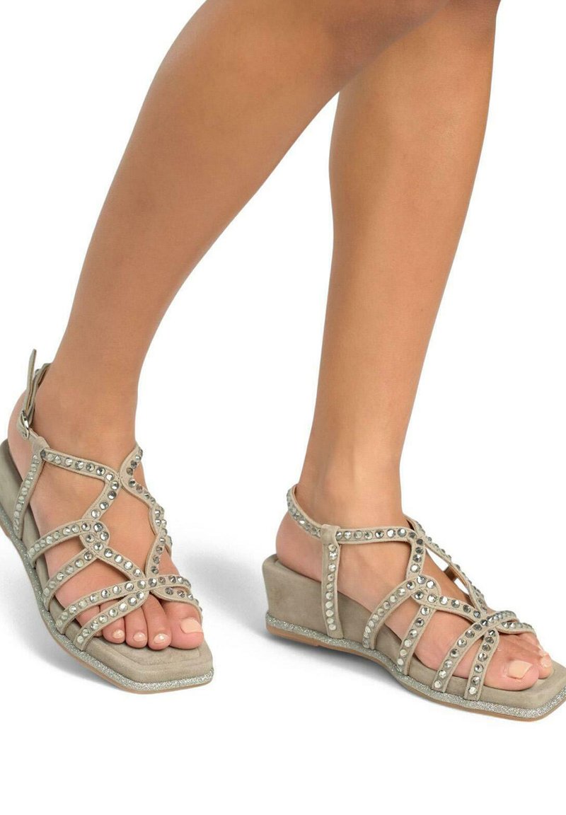 Sandali con tacco a cuneo in suede beige con dettagli di diamante, design open toe e una suola glitterata, che offre un contrasto testurizzato.