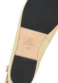 Semelle de chaussure en cuir beige avec talon et bouts noirs, embossée du logo KS, inscription « CUIR VERITABLE » et taille 37.