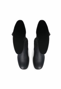 Zwarte leren enkellaarzen met een gladde textuur, ronde neus en een zijrits. Ontworpen zonder zichtbare veters of hardwareaccenten.