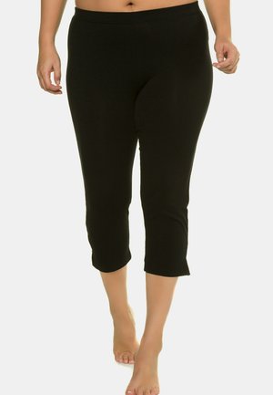 Schwarze Capri-Leggings aus dehnbarem Stoff, mit mittelhoher Taille und einer eng anliegenden Passform, die unter dem Knie endet und einen sauberen Saum hat.