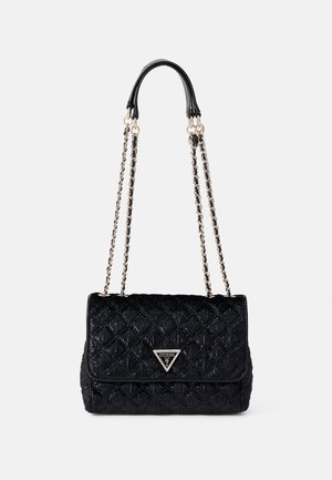 Sac à épaule matelassé noir avec bandoulières en chaîne dorée et logo triangulaire Guess sur le rabat avant.