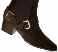 Botte de cheville en daim marron avec un embout pointu, une tige élastique sur les côtés et deux boucles dorées sur la sangle. Talon bloc avec une finition texturée.