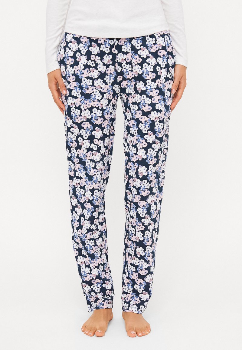Pantalons de pyjama fleuris en marine avec un motif de petites fleurs roses et blanches. Dotés d'une taille élastique et de poches latérales. Texture de tissu lisse.