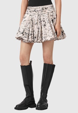 Plisseret mininederdel i lyserød med sort sprøjtmønster, lavet af blødt stof. Kombineret med knælange sorte læderstøvler.