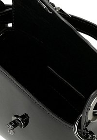 Interno di una borsa nera in pelle con una texture liscia, dotata di una chiusura in metallo argentato e una tasca laterale per l'organizzazione.