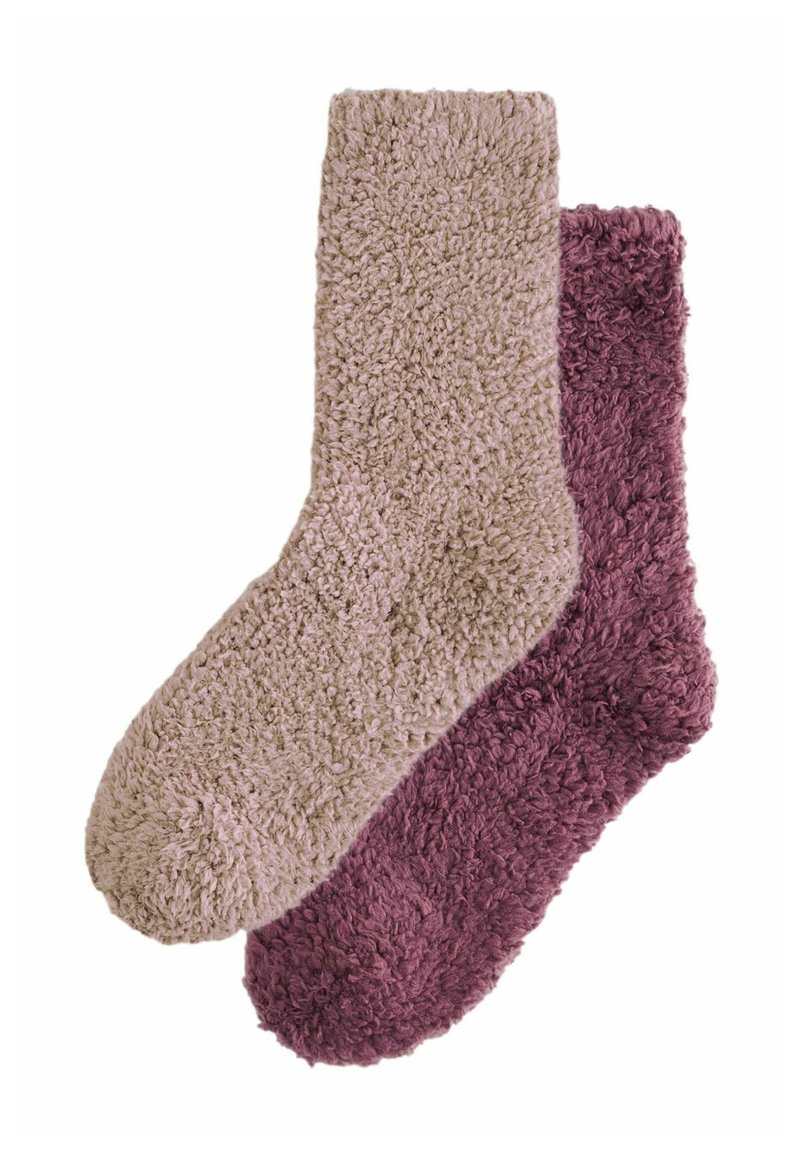 Ein Paar flauschige Socken: eine in hellem Beige und die andere in tiefem Burgunderrot. Beide besitzen eine weiche, strukturierte Oberfläche und runde Zehen.