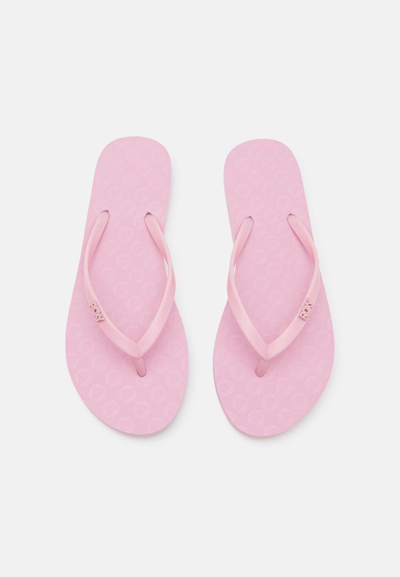Pink flip-flops with textured soles, thin straps, and Roxy branding. The design features a repeating pattern on the footbed.