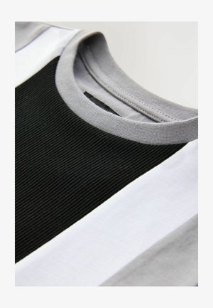 Koszulka z krótkim rękawem z prążkowanym czarnym środkowym panelem, szarymi rękawami i białymi paskami na dole, wykonana z miękkiego bawełnianego materiału.