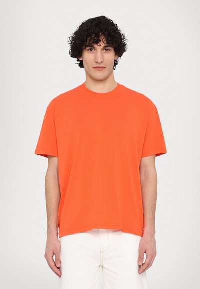 T-shirt a maniche corte, con scollo rotondo, in cotone di un vivace arancione. Vestibilità ampia con orlo dritto e senza motivi visibili o dettagli metallici.