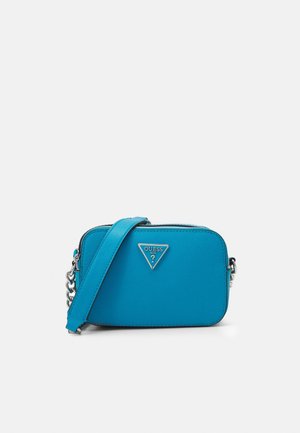 Un sac bandoulière compact turquoise en matériau synthétique texturé, avec des accents en chaîne argentée et un logo triangulaire sur le devant.