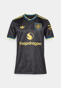 Μαύρη κοντομάνικη φανέλα ποδοσφαίρου με μπλε και κίτρινες λεπτομέρειες, που διαθέτει σήμα, λογότυπο "Snapdragon" και υφασμάτινο σχέδιο.
