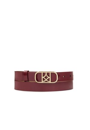 Ceinture en cuir bordeaux dotée d'une boucle en métal doré avec un design entrelacé des lettres "K" et "D". Texture lisse avec plusieurs trous pour un ajustement.