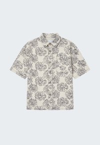 Chemise beige à manches courtes avec imprimé floral noir, boutons sur le devant, col à pointes et poche poitrine, étalée à plat sur un fond clair.