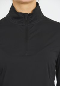 Zwarte lichtgewicht lange mouwen top met een hoge kraag en kwart rits, met een gladde textuur en een aansluitend ontwerp.