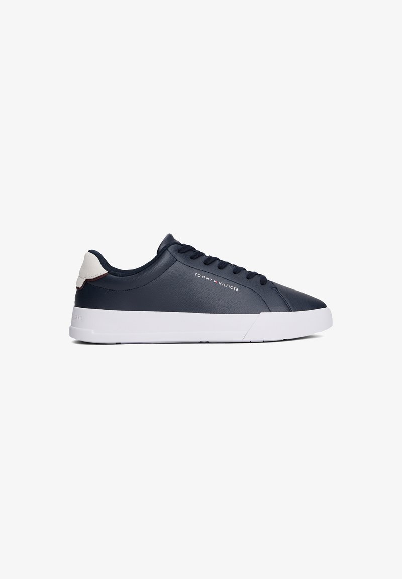 Baskets basses bleu marine avec semelle blanche, languette blanche au talon et logo "Tommy Hilfiger" sur le côté.