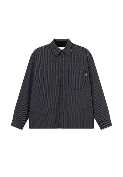 Langærmet skjorte i sort og hvidternet mønster, med krave, knapper foran og en enkelt brystlomme. Fremstillet af stof.