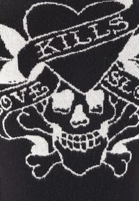 Black knit fabric featuring a white skull design with crossbones, surrounded by a band displaying the word "kills" in bold lettering.