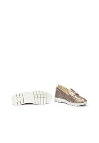 Zapatos deslizables metálicos en oro rosa con diseño perforado, suela blanca acolchada y punta redondeada. Cuenta con una cinta acolchada a lo largo del empeine.