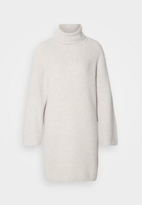 Robe pull à col roulé côtelée de couleur crème, manches longues et silhouette droite.