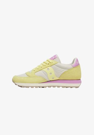 Sneaker profilata bassa in suede giallo, pannelli in tessuto crema, dettagli rosa sul tallone e sulla linguetta, suola bianca con striscia rosa.