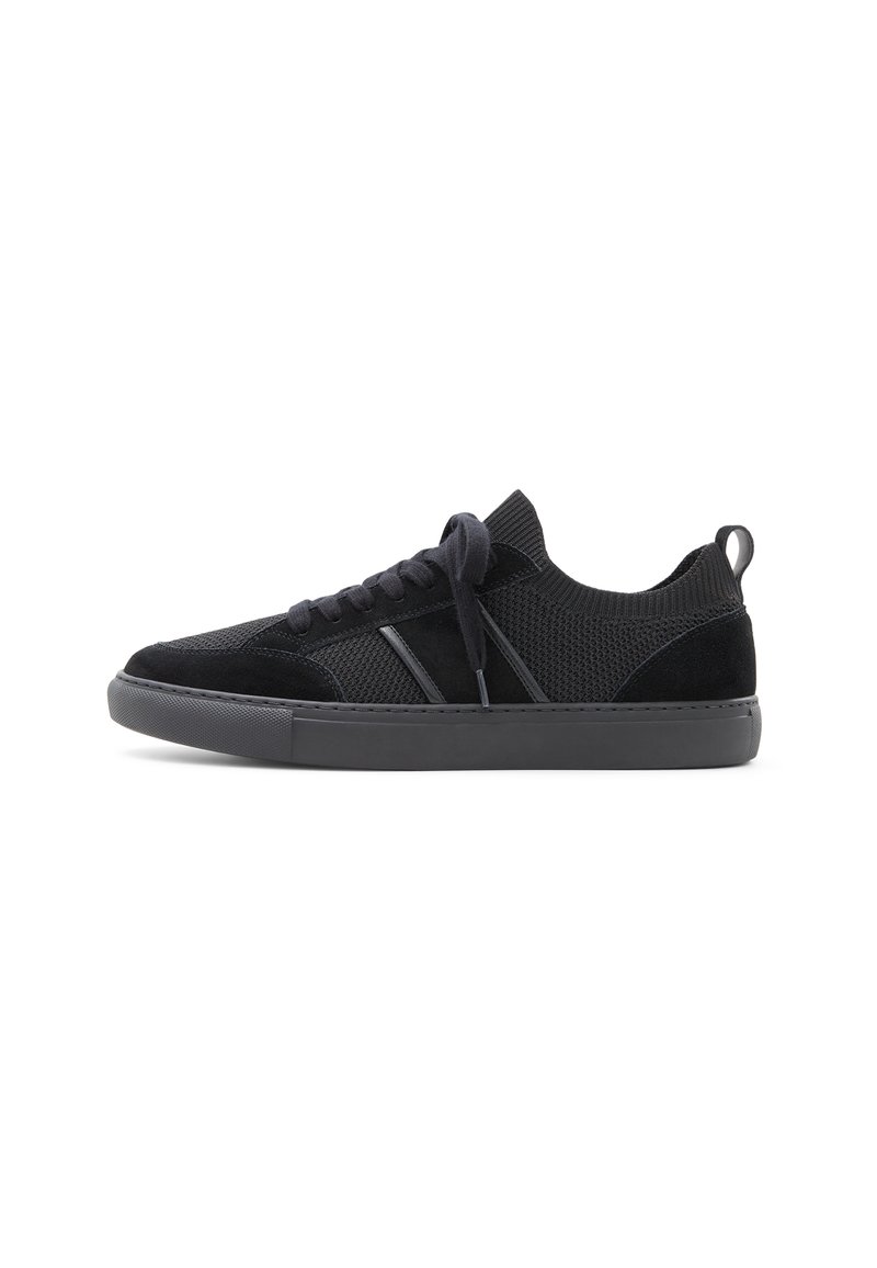 Zapatillas negras con parte superior de malla y acentos de ante. Presentan cordones planos, una puntera redondeada y una suela de goma gruesa para mayor durabilidad.