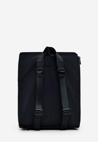 Black nylon bag with two adjustable straps, zip closure, and minimal design. Features reinforced patch at the top and sleek lines.