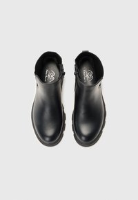 Botas negras hasta el tobillo con parte superior de cuero liso, paneles laterales elásticos y suela de goma texturizada. Presenta costuras duraderas y logotipos sutiles.