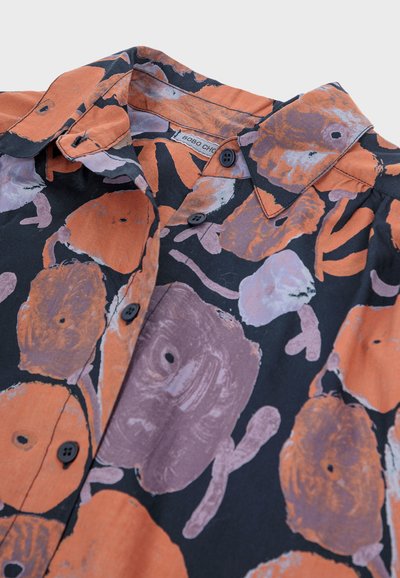 Camicia con base in tessuto nero, decorata con grandi motivi floreali arancioni e viola, colletto classico e bottoni neri sul davanti.
