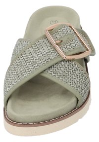 Sandal in tessuto verde con design a striscia incrociata, dotato di una fibbia metallica e una soletta testurizzata. Suola piatta con un leggero rialzo.