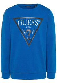 Sudadera azul con mangas largas, cuello redondo, que presenta un logo de triángulo negro y el texto "GUESS U.S.A. WASHED JEANS" en blanco y negro.