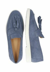 Blå mockaskor med tofsdetalj, vit gummisula, kontrasterande sömmar och design med rund tå. Inuti finns en beige foder.