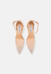 Scarpe con tacco alto trasparenti con punta affusolata, decorate con strass trasparenti. Presentano una sottile cinghia alla caviglia e un interno nudo.