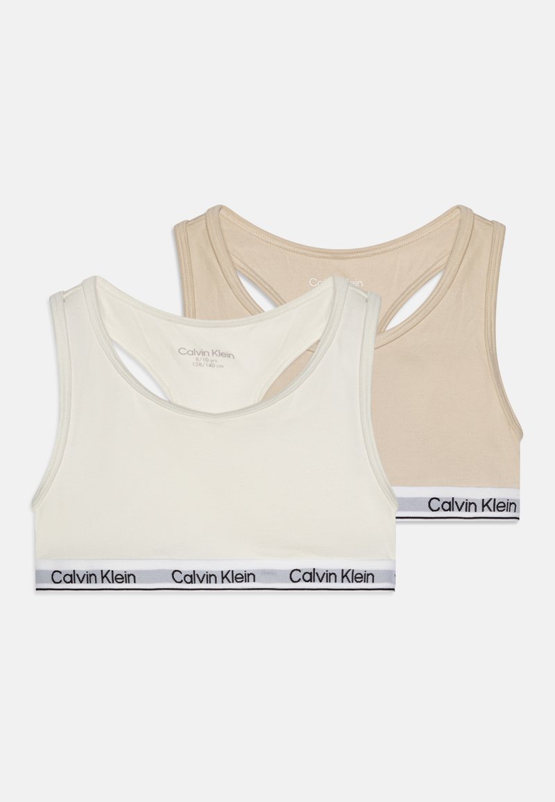 Dois braletes Calvin Klein em creme e bege. Tecido suave com design de costas nadador e faixa elástica com logotipo em branco e preto.