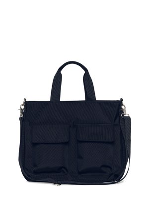 Bolsa tote rectangular negra con dos bolsillos delanteros con solapa, asas dobles y una correa de hombro ajustable y desmontable sobre fondo blanco.