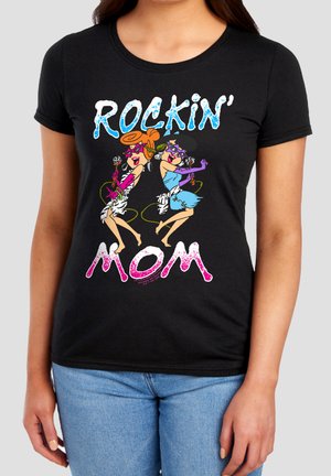 Woman wearing black t-shirt with colorful cartoon singers and text "Rockin' Mom" in blue and pink letters.