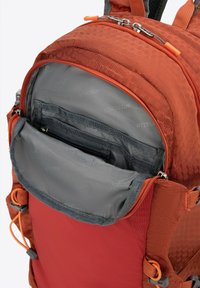 Orange hexagonal-patterned backpack with gray interior. Features double zippers, multiple compartments, and adjustable straps for comfort.
